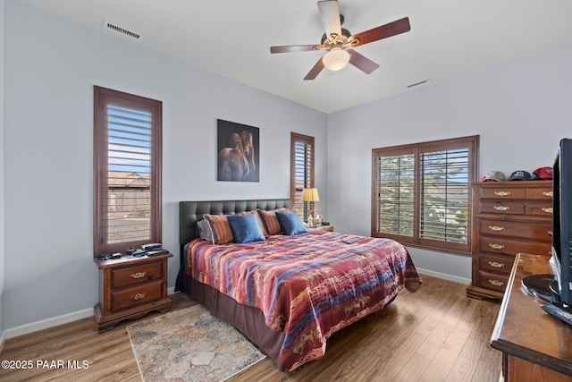 bedroom featuring visible vents, baseboards, a ceiling fan, and light wood finished floors