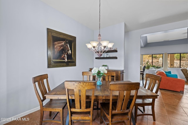 tiled dining area featuring a chandelier and baseboards