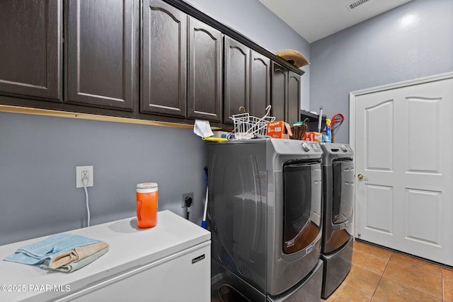 laundry room featuring light tile patterned floors, cabinet space, visible vents, and washing machine and clothes dryer