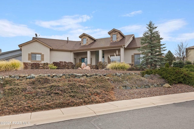 view of front facade featuring stone siding and stucco siding