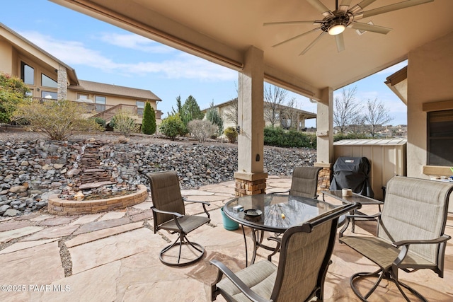 view of patio with outdoor dining space, an outbuilding, and ceiling fan