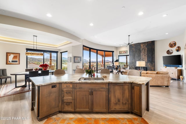 kitchen with pendant lighting, an island with sink, and sink