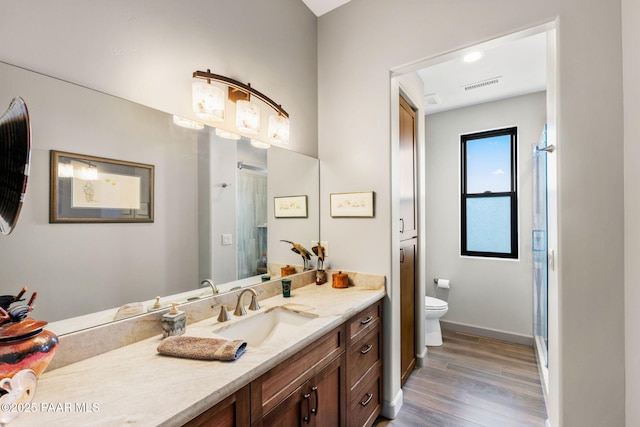 bathroom with walk in shower, toilet, vanity, and hardwood / wood-style flooring