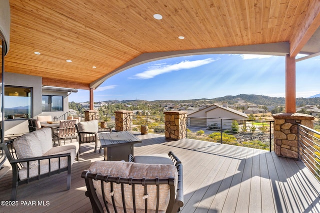 wooden terrace featuring a mountain view and an outdoor hangout area