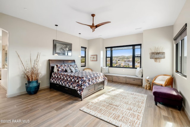 bedroom featuring hardwood / wood-style floors, ceiling fan, and ensuite bathroom