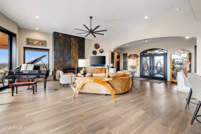 living room featuring a tile fireplace, french doors, and ceiling fan