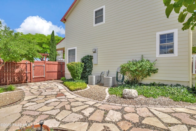 exterior space with central AC unit, a gate, and fence