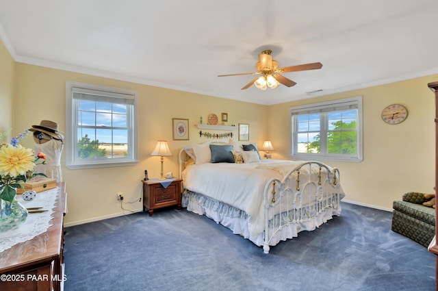 bedroom with multiple windows, dark colored carpet, baseboards, and ornamental molding