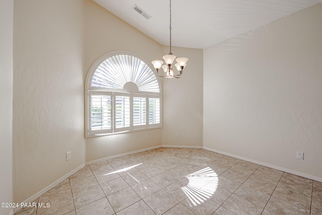 unfurnished room with light tile patterned flooring, a chandelier, and lofted ceiling