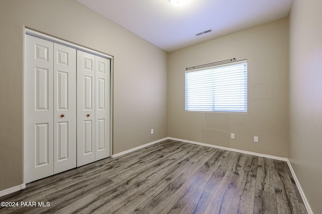 unfurnished bedroom featuring hardwood / wood-style flooring and a closet