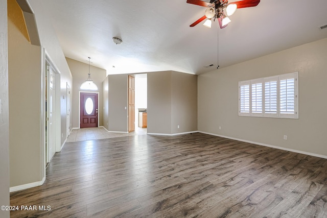 unfurnished living room with ceiling fan, wood-type flooring, and lofted ceiling