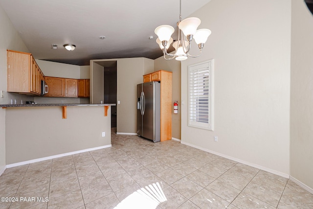 kitchen featuring stainless steel appliances, an inviting chandelier, a kitchen breakfast bar, kitchen peninsula, and decorative light fixtures