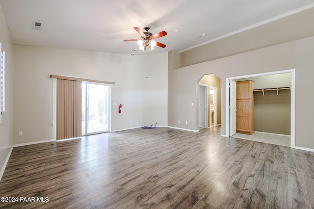 unfurnished bedroom featuring access to exterior, ceiling fan, hardwood / wood-style flooring, a spacious closet, and a closet