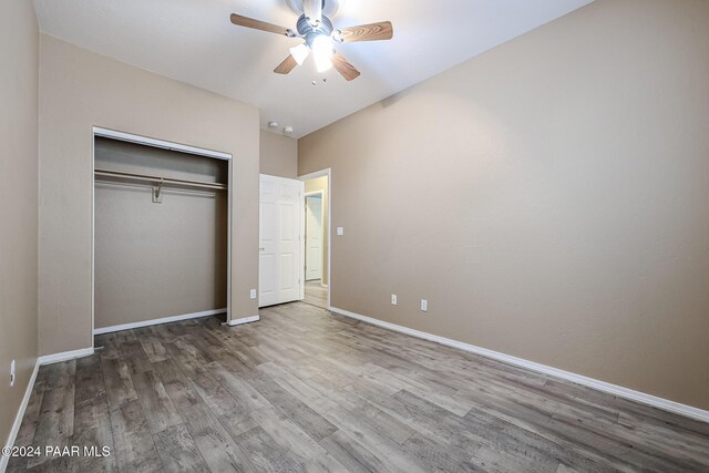 unfurnished bedroom with hardwood / wood-style flooring, ceiling fan, and a closet