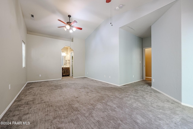 carpeted spare room with vaulted ceiling and ceiling fan