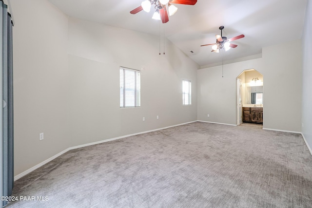 carpeted spare room featuring ceiling fan and lofted ceiling