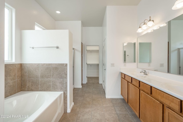 bathroom with a bath, vanity, and tile patterned floors