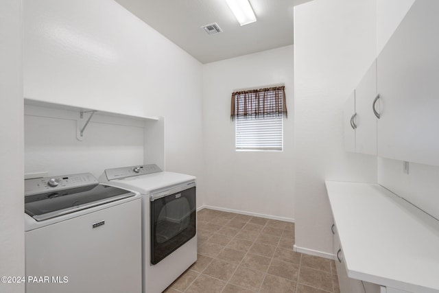 laundry room featuring washing machine and clothes dryer and cabinets