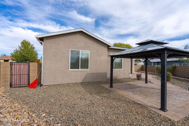 view of side of home with a gazebo and a patio