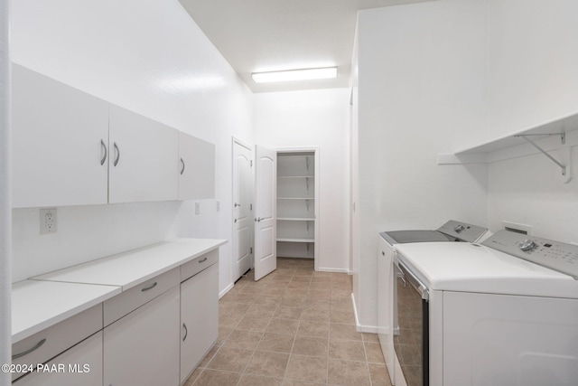 clothes washing area featuring cabinets and independent washer and dryer