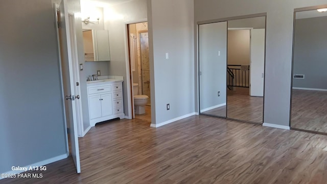 3035 Hozoni Rd, Prescott, AZ 86305 - unfurnished bedroom featuring wood finished floors, multiple closets, and ensuite bath