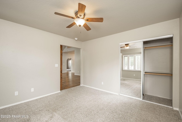 unfurnished bedroom featuring a closet, baseboards, a ceiling fan, and carpet flooring