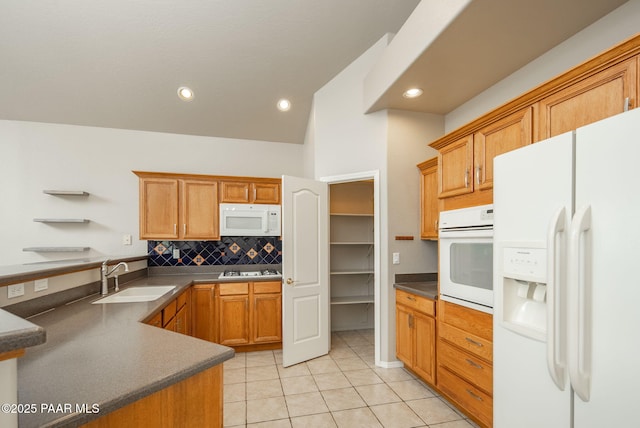 kitchen with white appliances, light tile patterned floors, a sink, decorative backsplash, and dark countertops