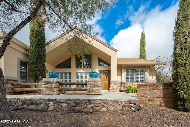 exterior space featuring stucco siding and stone siding