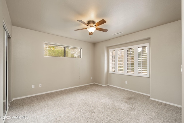 unfurnished bedroom with baseboards, visible vents, carpet floors, ceiling fan, and a closet