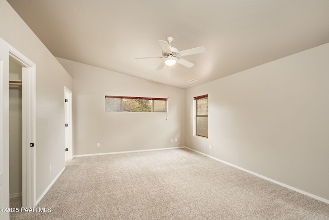 carpeted spare room with baseboards, lofted ceiling, and a ceiling fan