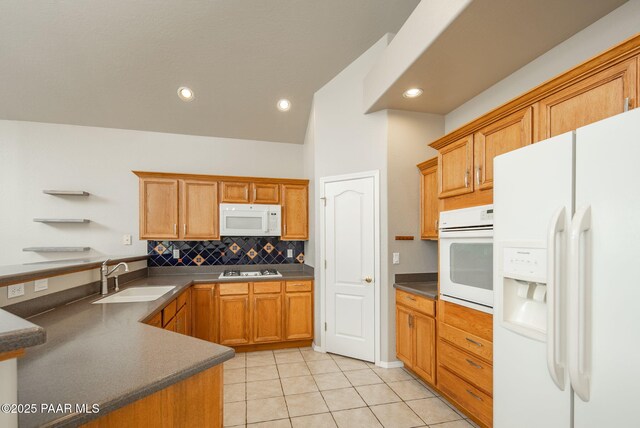 kitchen featuring a sink, dark countertops, white appliances, light tile patterned flooring, and decorative backsplash