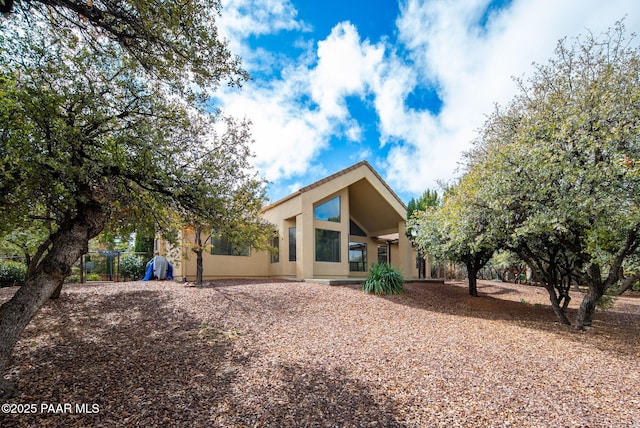 rear view of property featuring stucco siding