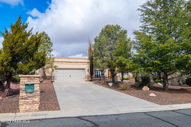 view of front facade featuring stucco siding, concrete driveway, and a garage