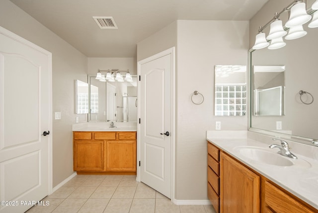 bathroom with tile patterned flooring, visible vents, two vanities, and a sink