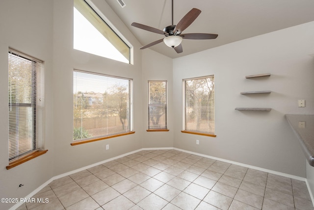 unfurnished room with baseboards, light tile patterned flooring, a ceiling fan, and vaulted ceiling