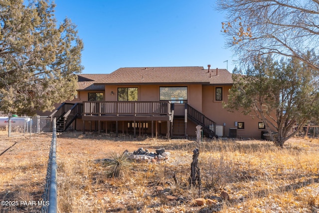 rear view of property featuring central AC unit, stucco siding, stairs, and a deck