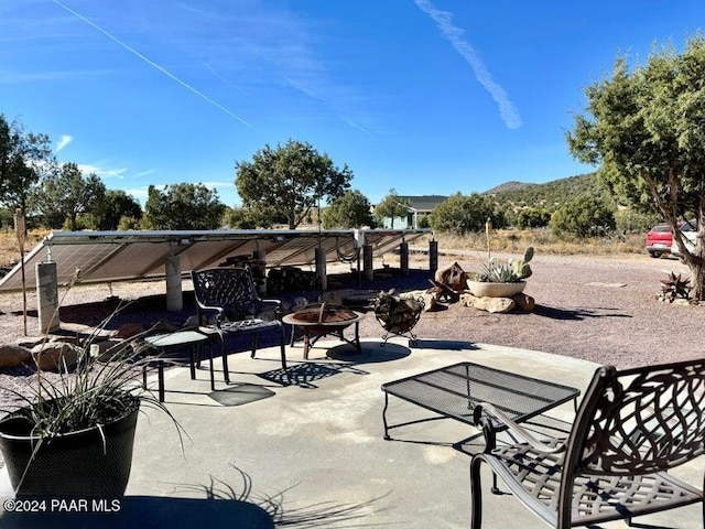 view of patio with a mountain view and an outdoor fire pit