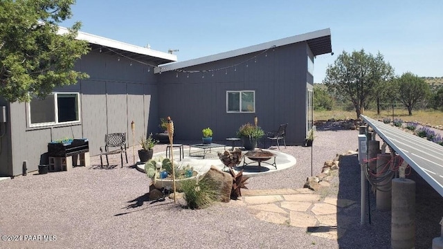 rear view of house featuring a patio area and a fire pit