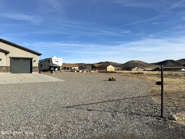 view of yard with a garage and a mountain view