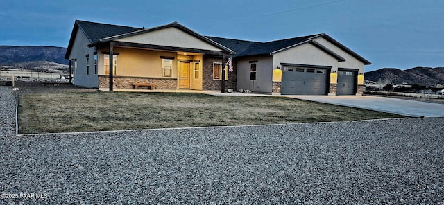 view of front of property with a mountain view, a garage, and a front lawn