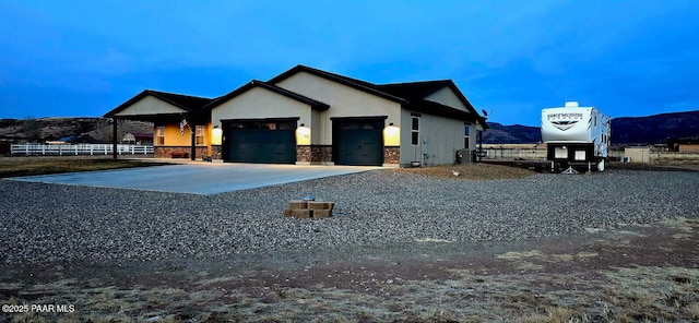 view of front of house featuring a garage, a mountain view, and central AC