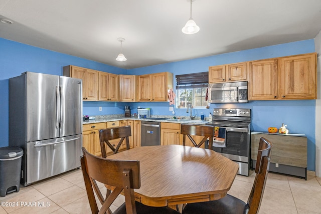 kitchen with pendant lighting, appliances with stainless steel finishes, sink, and light tile patterned floors