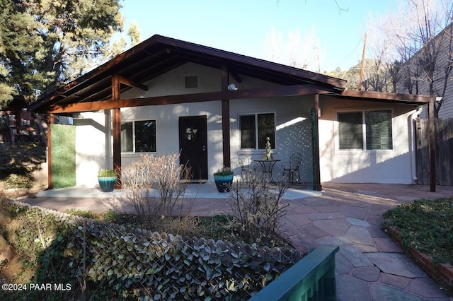 view of front facade with a patio and stucco siding