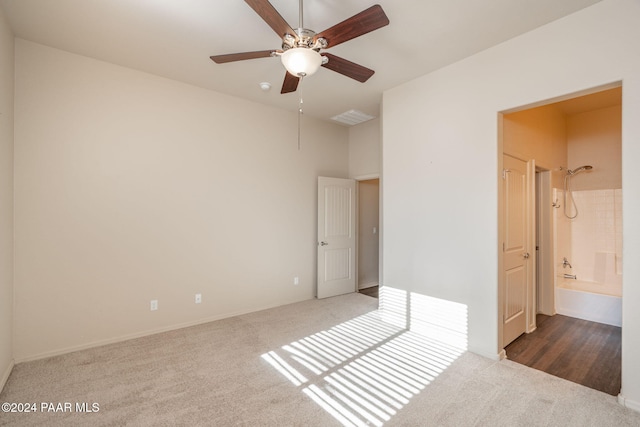 unfurnished bedroom featuring carpet flooring, ensuite bath, and ceiling fan