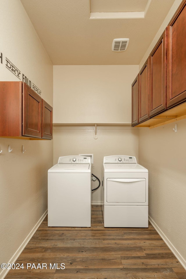 laundry area featuring cabinets, dark wood-type flooring, and washing machine and dryer