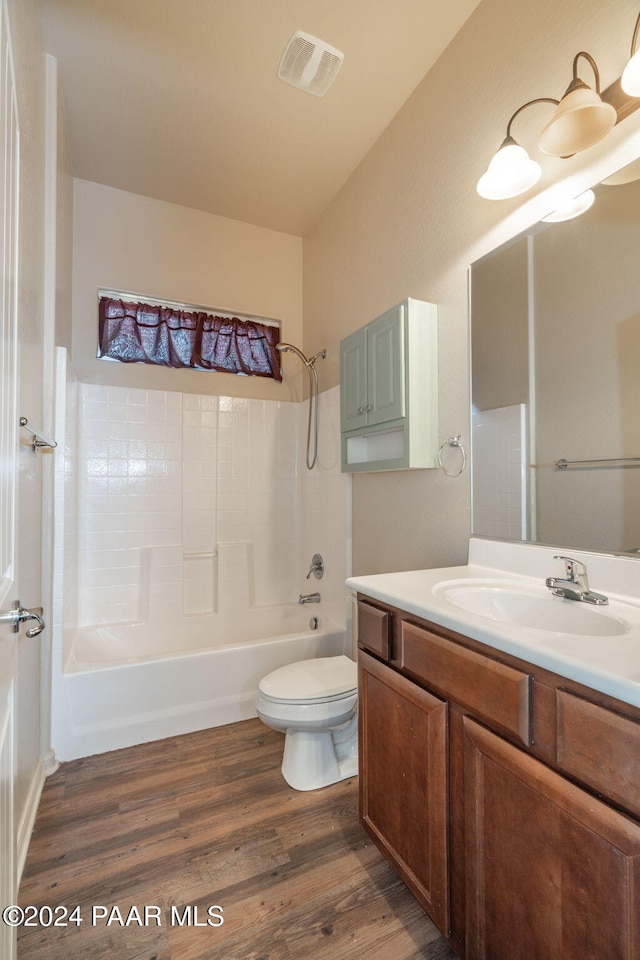 full bathroom featuring hardwood / wood-style floors, vanity, toilet, and shower / bathtub combination