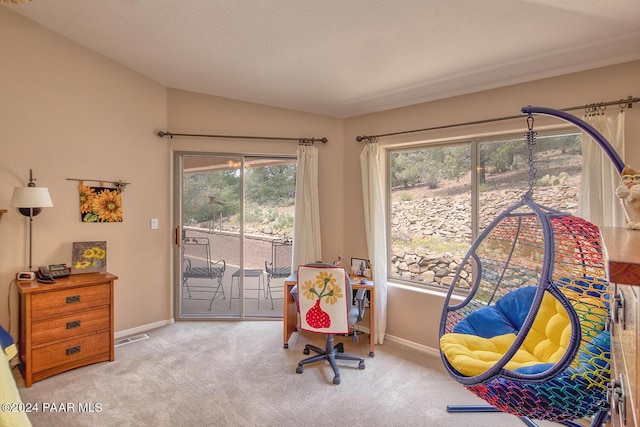 interior space featuring light colored carpet, vaulted ceiling, and plenty of natural light