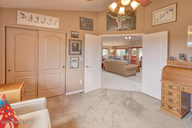 interior space with ceiling fan, carpet, and lofted ceiling