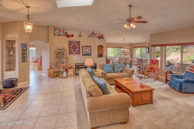 living room with ceiling fan, light tile patterned flooring, and vaulted ceiling