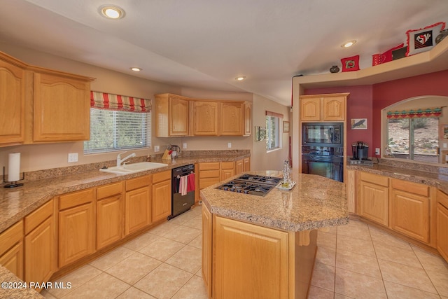 kitchen featuring light brown cabinetry, sink, black appliances, light tile patterned floors, and a center island